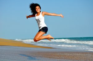 happy girl jumping with joy by the sea