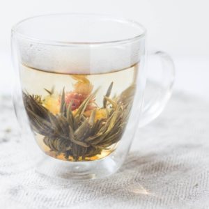 glass cup of herbal tea on white background