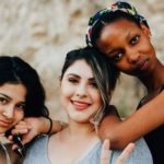 three ethnically different young girls smiling happily